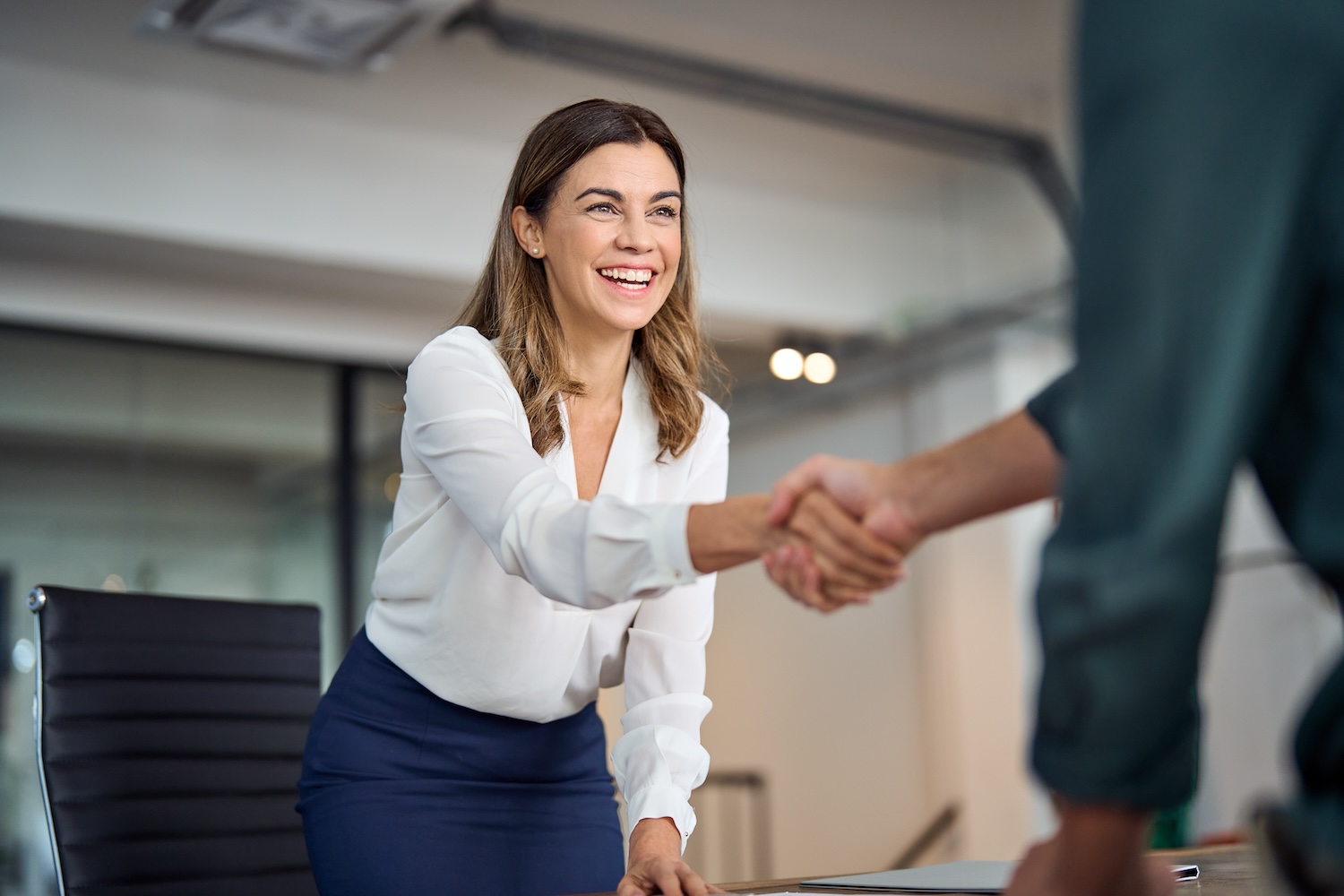A woman shaking hands with a client